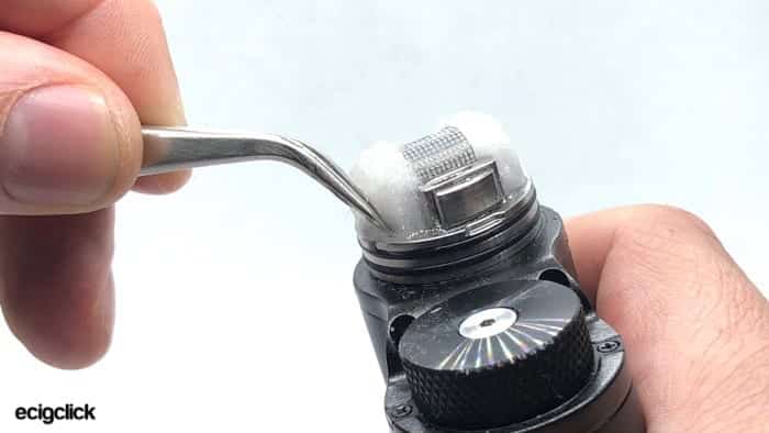 Placing saturated cotton into the deck of the Meshlock RDA with tweezers
