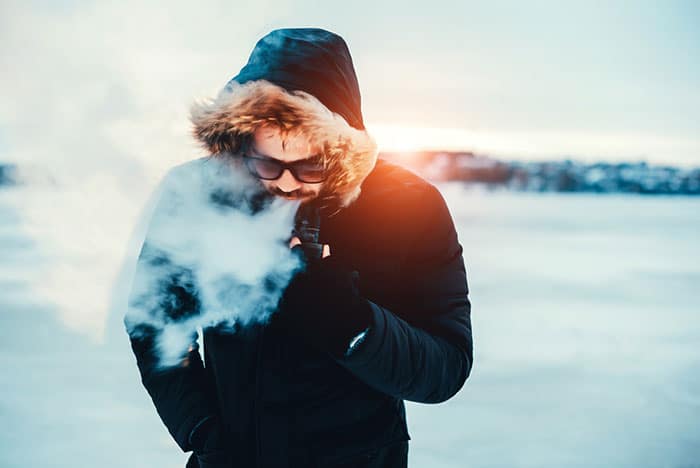 man vaping in snow